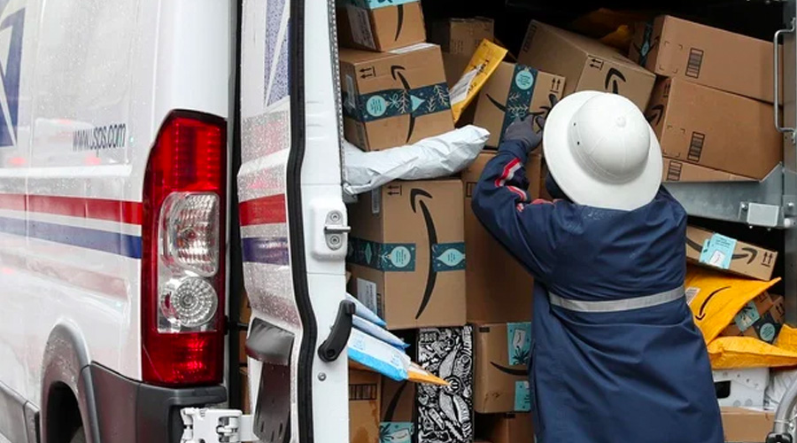 Mail worker loading Amazon parcels into truck